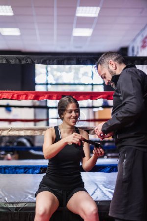 Foto de Artes marciales y gerente de autodefensa ayudan a un boxeador o boxeador a poner las envolturas protectoras del equipo de ropa deportiva. - Imagen libre de derechos