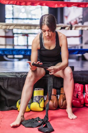 Foto de Determinación de estilo de vida saludable y motivación para las artes marciales autodefensa MMA o Kickboxing. Mujer poniendo en equipo de protección - Imagen libre de derechos