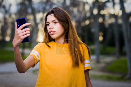 Photo for Mobile phone communication technology. Attractive Hispanic young woman online connection with casual clothes outdoors with copy space - Royalty Free Image