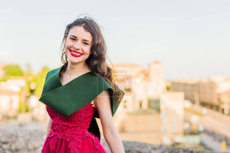 Photo for Success and achievement bachelor degree. Happiness portrait in Salamanca Campus with long dress and graduation stole. One person in Europe, Spain - Royalty Free Image