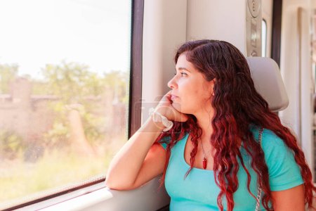 Téléchargez les photos : Transports publics voyageurs ferroviaires assis. Portrait d'une personne, touriste d'origine vénézuélienne profiter sans soucis d'un voyage sur un siège de fenêtre - en image libre de droit