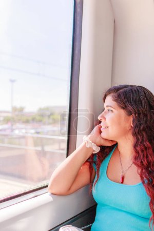 Téléchargez les photos : Transports publics voyageurs ferroviaires assis. Portrait d'une personne, touriste d'origine vénézuélienne profiter sans soucis d'un voyage sur un siège de fenêtre - en image libre de droit