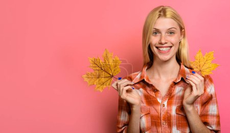 Mujer de otoño. Chica sonriente en ropa casual con hojas de arce amarillo. Tendencias de moda para el otoño