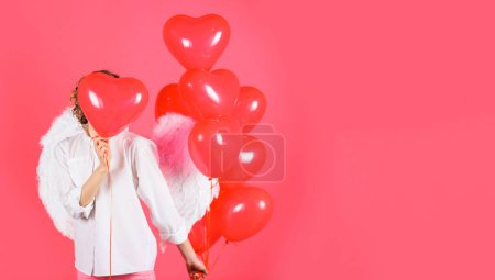 Valentines day. Angel woman in angelic wings with heart shaped balloons. Copy space