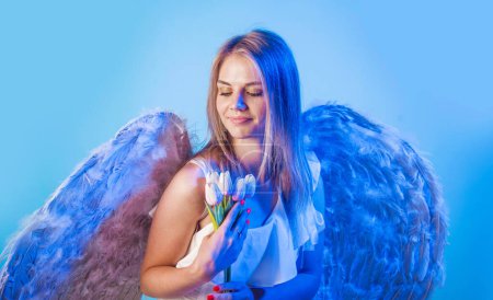 Valentines Day. Cute angel with flowers. Angelic girl in white wings with tulips