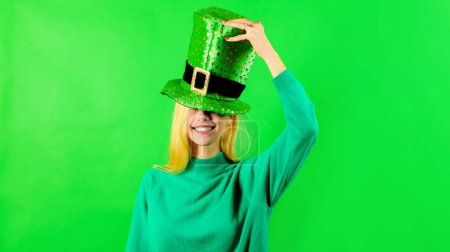 Patricks Day. Smiling blonde girl in green top hat celebrate Patricks Day. Happy woman in green Leprechaun hat with clover. Irish traditions. Patrick day party celebration. Irish traditions