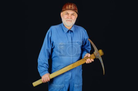 Photo for Miner man with pickaxe. Construction worker with pickaxe. Male laborer with building tools. Bearded man builder in uniform and hardhat with pickax. Workman in safety helmet and coveralls with pick ax - Royalty Free Image