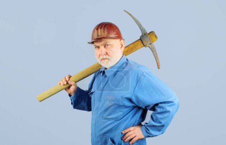 Photo for Serious miner worker in uniform with pickaxe. Construction and building works. Bearded man in coveralls and hard hat with pick axe. Craftsman working with pick-axe. Male laborer with building tool - Royalty Free Image