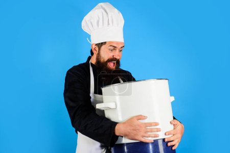 Photo for Happy bearded man in chef hat and uniform with casserole or saucepan. Male chef cook in apron with big pot or pan. Cookware, dinnerware, kitchenware and kitchen utensils concept. Cooking and culinary - Royalty Free Image