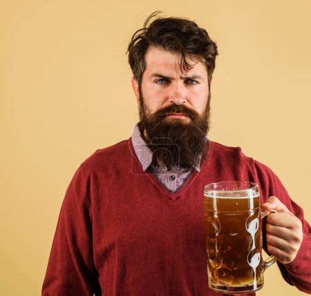 Bierzeit. Ernsthafter Mann mit Bart und Schnurrbart, der in Kneipe oder Bar Bier trinkt. Alkohol. Stilvoller bärtiger Mann mit Bierkrug. Hübsche Männer probieren Craft Beer im Restaurant. Oktoberfest-Feier