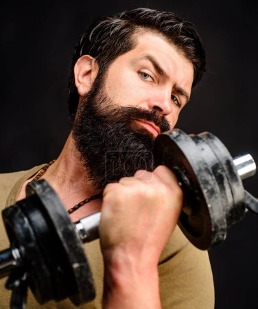 Photo for Strong bearded muscular sportsman lifting dumbbell. Closeup portrait. Sporty bodybuilder pumping muscles with dumbbell. Weightlifting and bodybuilding. Handsome athlete fitness model raising dumbbell - Royalty Free Image
