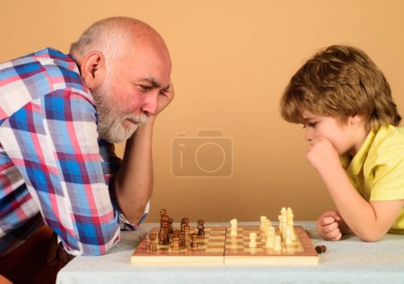 Chess competition. Grandfather and grandson playing chess. Child boy play chess with granddad. Brain development and logic concept. Little boy thinking about next move in game of chess. Board games