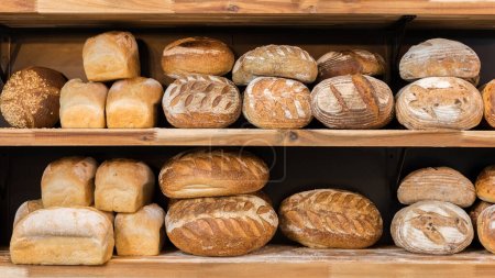 Foto de Pan recién horneado en un estante. Panes del mercado de pan escaparate - Imagen libre de derechos