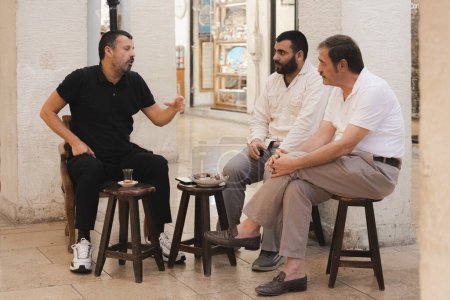 Téléchargez les photos : Istanbul, Turquie - 1er octobre 2022 : Des hommes turcs socialisent et discutent autour du thé traditionnel et du Délice turc au Grand Bazar d'Istanbul. - en image libre de droit