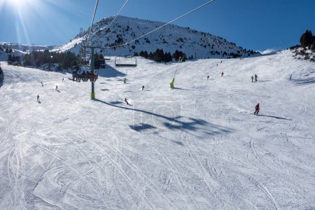 Foto de Ski slope with skiers sliding down the slope in the Pyrenees, Andorra, photo with copyspace - Imagen libre de derechos