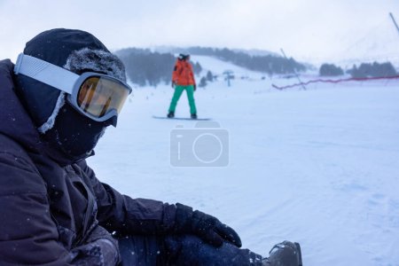 Foto de Skier sitting in the snow of the ski slopes, resting from the effort, photo with copyspace - Imagen libre de derechos