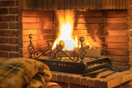 Téléchargez les photos : Couverture pour garder au chaud devant le feu confortable de la cheminée à l'intérieur de la maison - en image libre de droit