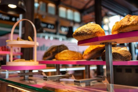 Téléchargez les photos : Vitrine de boulangerie avec étagères et pains de différents types exposés à la vente au public, Mercado de San Miguel, Madrid - en image libre de droit