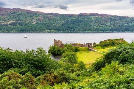 Photo for Medieval Urquhart Castle on the shore of Loch Ness on a hill overlooking the beautiful landscape, Scotland, UK - Royalty Free Image