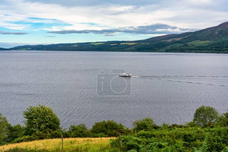 Photo for Boat sailing on the huge Loch Ness in central Scotland, surrounded by mountains - Royalty Free Image