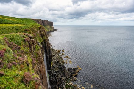 Téléchargez les photos : Falaises avec cascade qui tombe dans la mer sur l'île magnifique de Skye, Écosse - en image libre de droit