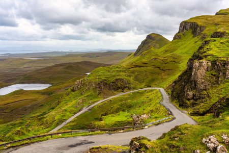 Téléchargez les photos : Route qui serpente entre les collines verdoyantes du magnifique paysage de l'île de Skye, en Écosse - en image libre de droit