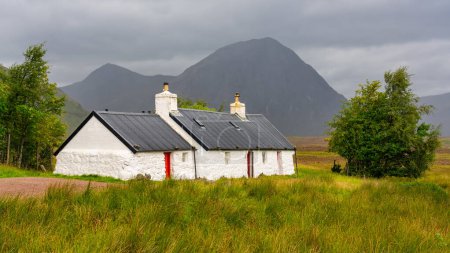 Foto de Pequeña casa perdida en las montañas del valle de Glencoe en las Highlands de Escocia - Imagen libre de derechos