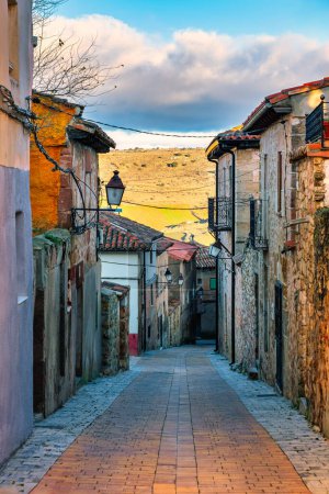 Téléchargez les photos : Ruelle pittoresque avec vieilles maisons et rue escarpée au coucher du soleil à Siguenza, Espagne. - en image libre de droit