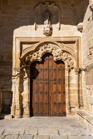 Holztür an der mittelalterlichen Steinfassade der Kirche in Trujillo, Spanien