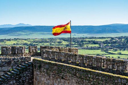 Die spanische Flagge weht im Wind auf der mittelalterlichen Burg von Trujillo, Extremadura