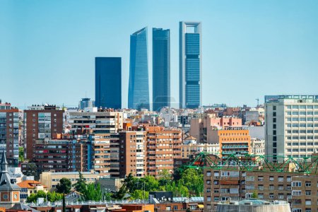 Four skyscraper towers of Madrid emerging among the buildings of the city, Spain