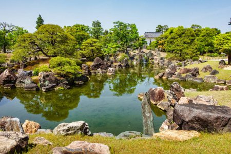 Japanischer Garten mit Wasserteich, Felsen und grünen Pflanzen auf der Burg Nijo, Japan