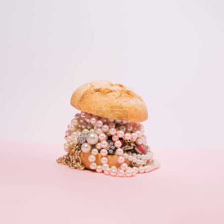 Foto de Hamburguesa creativa con joyas sobre fondo rosa pastel. Concepto de comida rápida estética. - Imagen libre de derechos