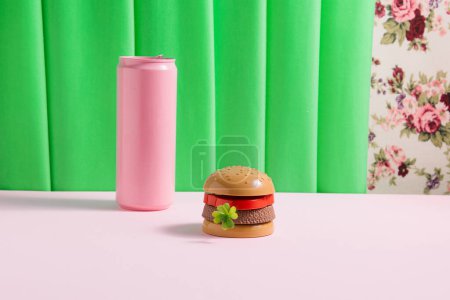 Plastic burger and pink soda can, creative retro aesthetic. Nostalgia for the 1950s.