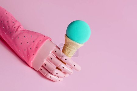 Photo for Wooden hand model, waffle cone in it and ocean blue ball, creative aesthetic concept, summer holidays, blue moon flavor ice cream idea. - Royalty Free Image