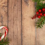 fir branch and red christmas decoration on the wooden background