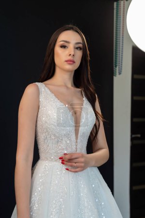 Beautiful young bride posing in a wedding dress in a studio in a wedding dress