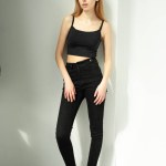 beautiful young girl in black pants posing in studio on white background
