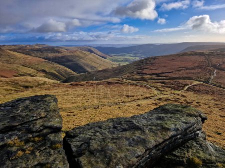 A stunning panoramic view of the Peak District's undulating hills and weaving pathways, captured on a clear day, showcasing the natural beauty of England's countryside.