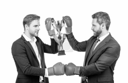 Téléchargez les photos : Deux hommes d'affaires en gants de boxe tiennent la coupe du champion d'or après la bataille d'entreprise pour le leadership, la victoire. - en image libre de droit