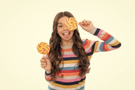 making faces. happy girl hold lollipop isolated on white. lollipop child. kid in colorful sweater hold lollypop. sugar candy on stick. candy shop. childhood. teen dental care. sweet tooth. yummy.
