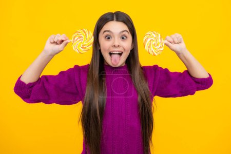 Photo for Excited face. Teen girl hold lollipop caramel on yellow background, candy shop. Teenager with sweets suckers. Amazed expression, cheerful and glad - Royalty Free Image