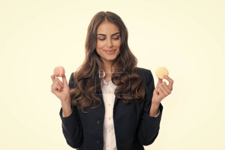 Téléchargez les photos : Jeune femme mangeant un délicieux macaron sur fond blanc. Fille manger le macaron - en image libre de droit
