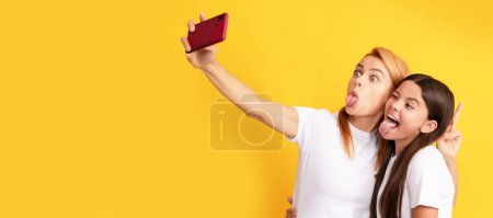 Photo for Mother and daughter kid banner, copy space, isolated background. funny woman and girl take selfie with mobile phone. selfie family. modern life. mobile technology - Royalty Free Image
