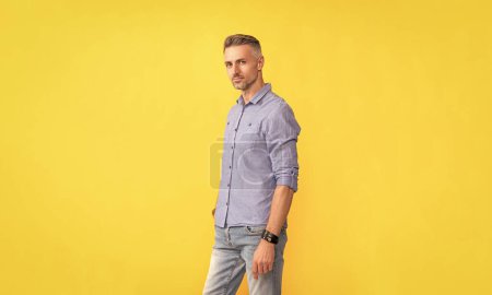 handsome guy with graying bristle. mens beauty. hoary man portrait with grizzled hairstyle. adult man with gray beard. hair and beard care. male fashion model on yellow background.