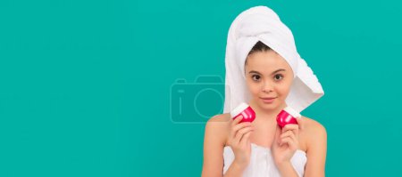 Photo for Smiling kid in bath tower choose skin cream, skincare. Cosmetics and skin care for teenager child, poster design. Beauty kid girl banner with copy space - Royalty Free Image