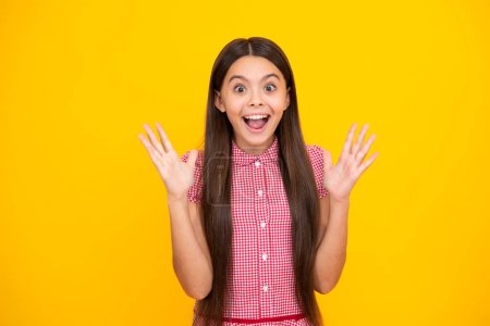 Photo for Amazed teen girl. Portrait of joyful child girl with raised hands. Caucasian teenager screaming isolated on yellow. Excited expression, cheerful and glad - Royalty Free Image