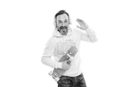 Photo for Happy mature man skateboarder with beard in hoody listen music wearing headphones hold penny skateboard isolated on white, having fun. - Royalty Free Image
