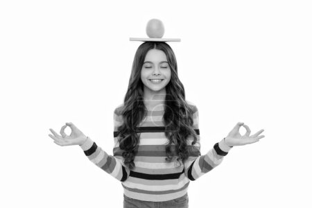 Téléchargez les photos : Heureux adolescent fille avec orange fruit et école copybook sur la tête méditant isolé sur blanc, méditation. - en image libre de droit