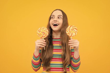 Foto de Teenage girl with lollipop, child eating sugar lollipops, kids sweets candy shop. Excited face, cheerful emotions of teenager girl - Imagen libre de derechos